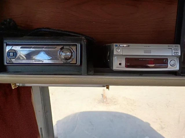 Integrated entertainment system featuring a silver-toned head unit and a stacked DVD/CD player, set within a wood-finish cabinet