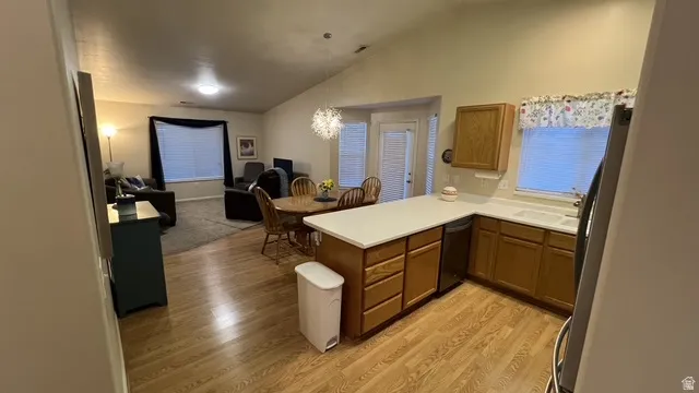 Open-concept living area featuring a kitchen with light wood-finish cabinetry and white countertops