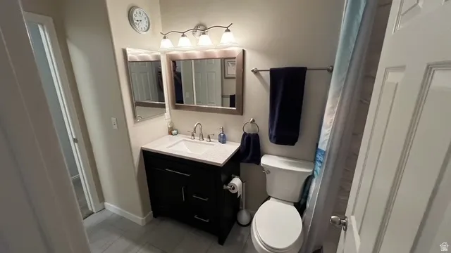 Bathroom featuring a dark wood-finish vanity with a light-colored countertop, an undermount sink, and a framed mirror