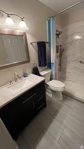 Bathroom featuring a dark wood-finish vanity with a light-toned countertop, a built-in sink, and brushed nickel fixtures