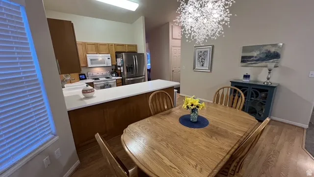 Open-concept kitchen and dining area featuring a light wood-finish dining table and coordinating chairs