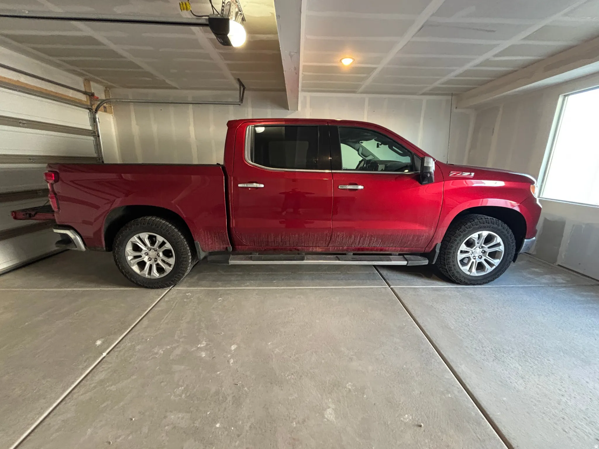 Spacious garage featuring concrete flooring and a large window