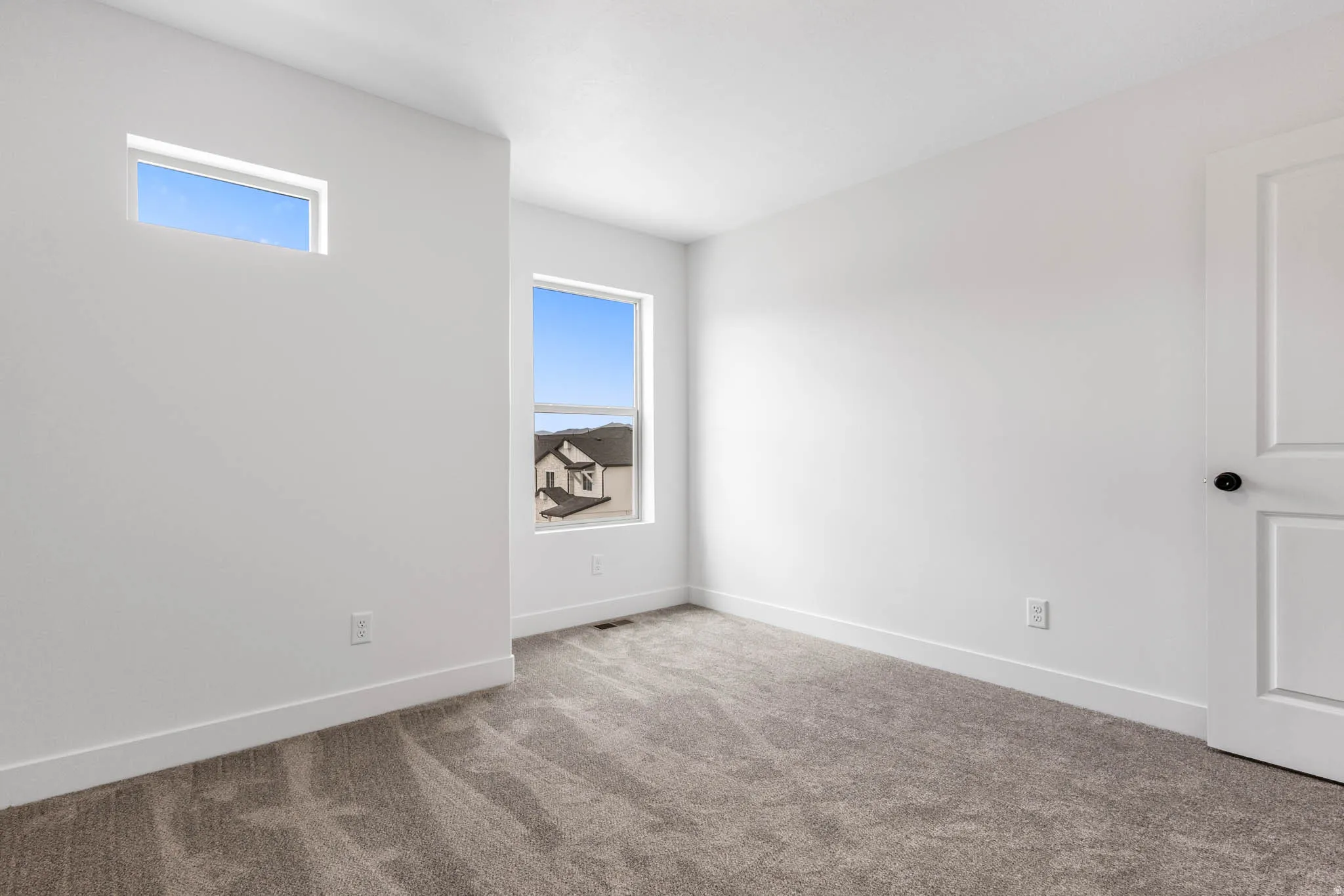 Neutral interior featuring light-toned walls, gray carpeting, and white trim