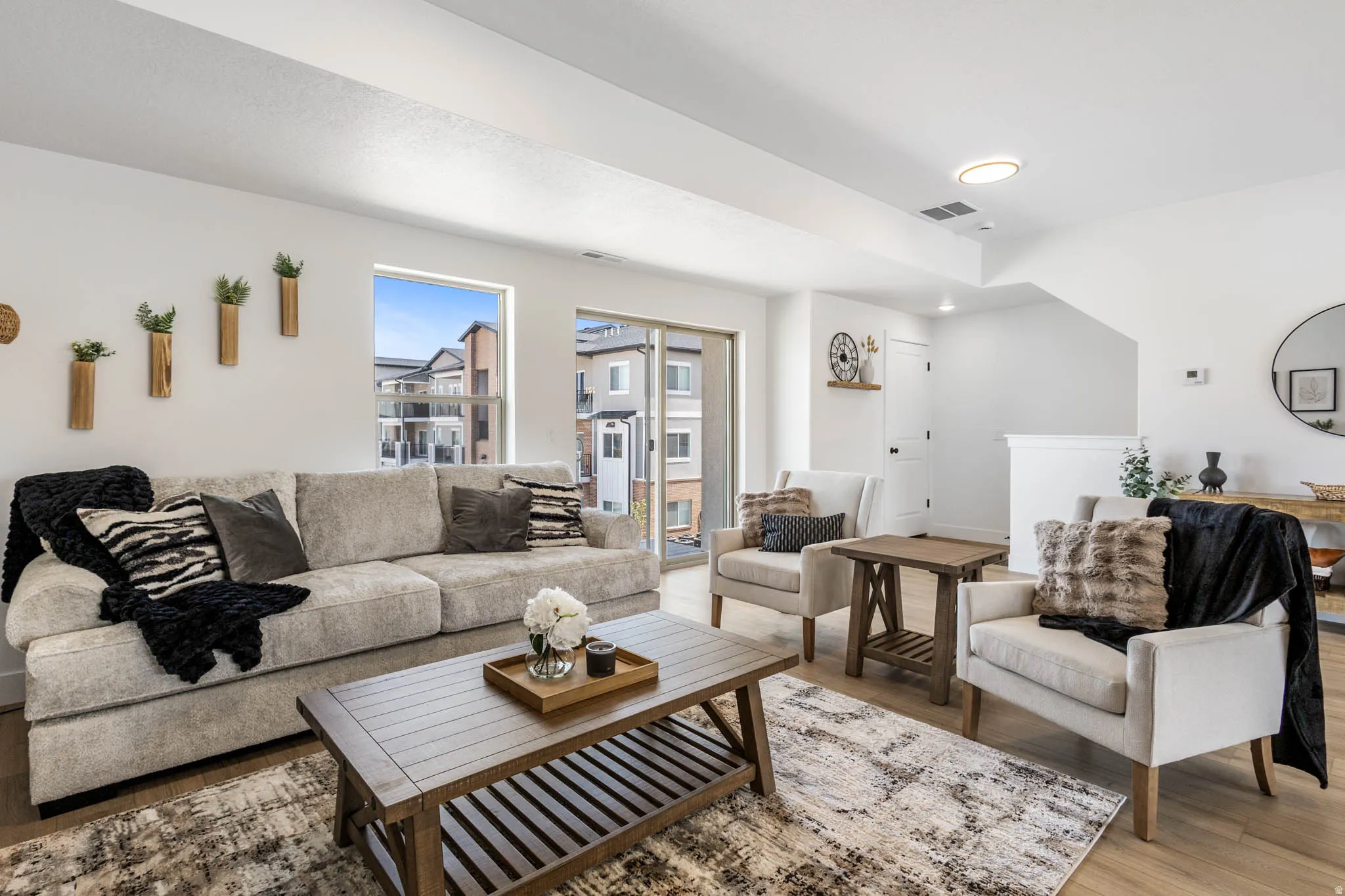 Bright living area featuring wood-finish flooring, a large window, and a sliding glass door