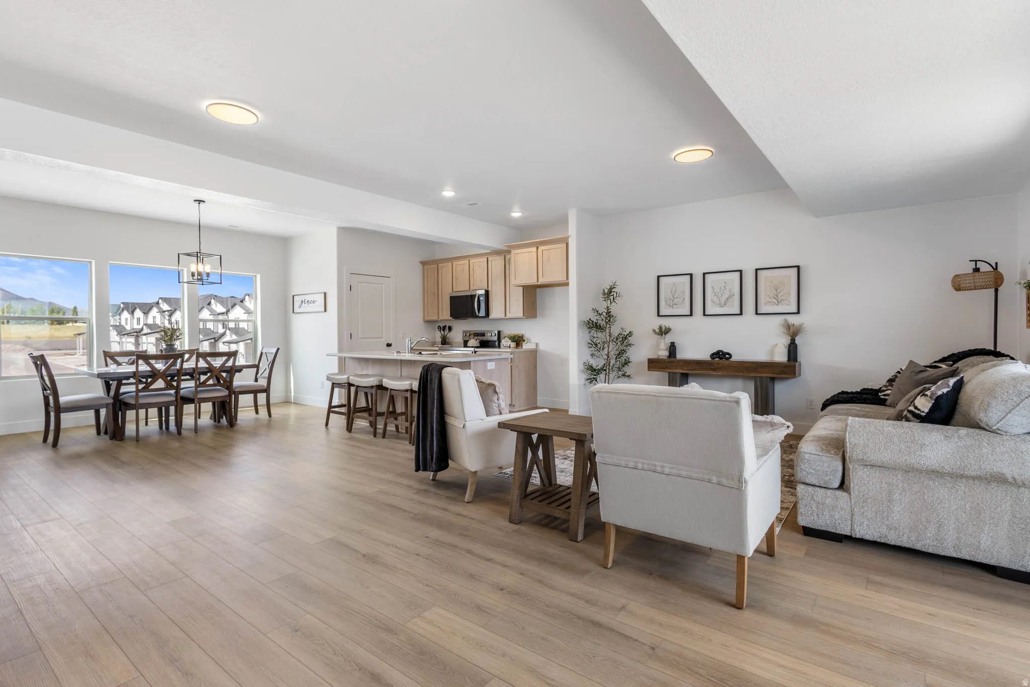 Open-concept living area featuring wood-finish flooring, recessed lighting, and large windows