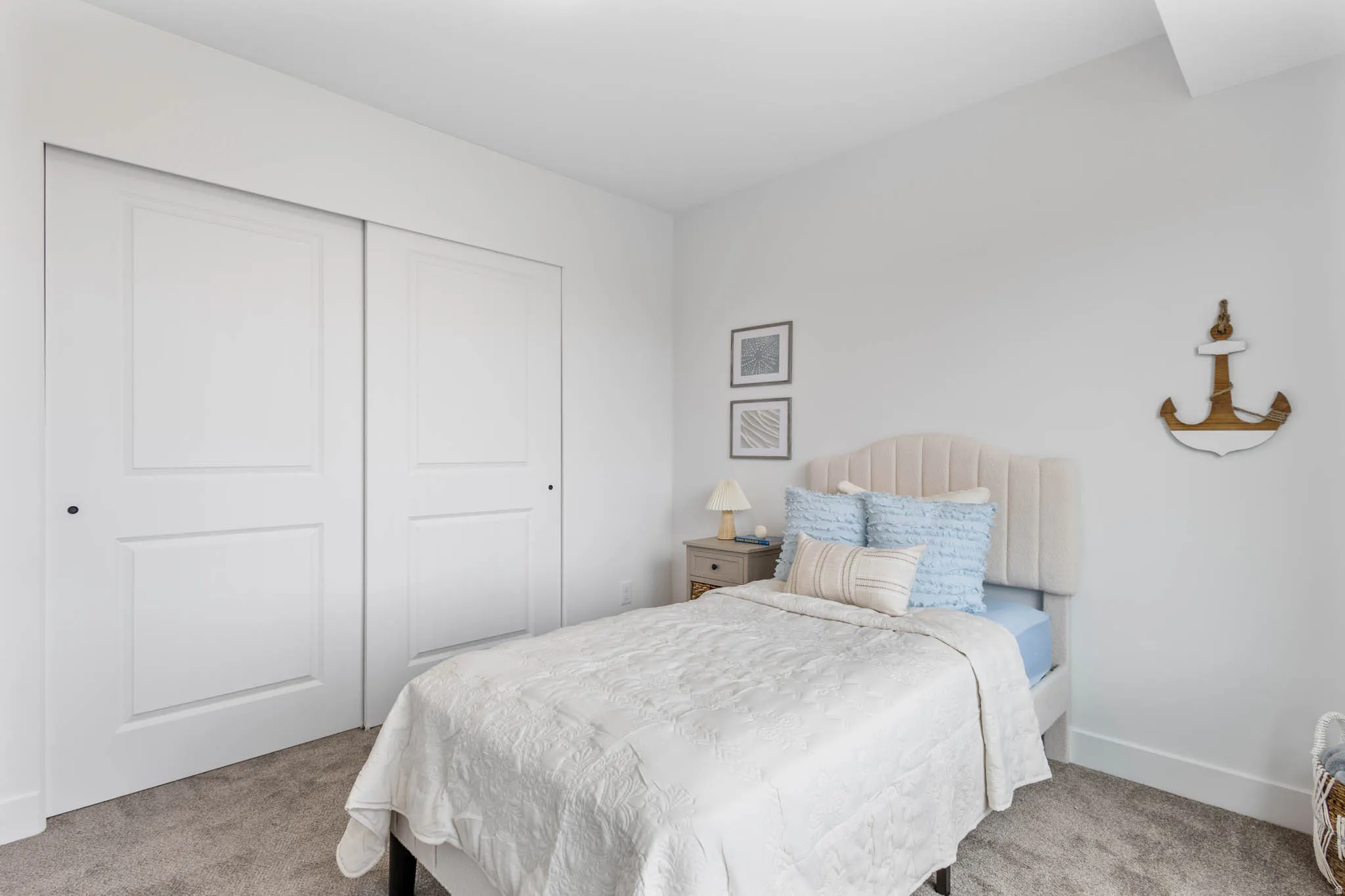 Bedroom with white walls, grey carpet, and a large closet with sliding panel doors