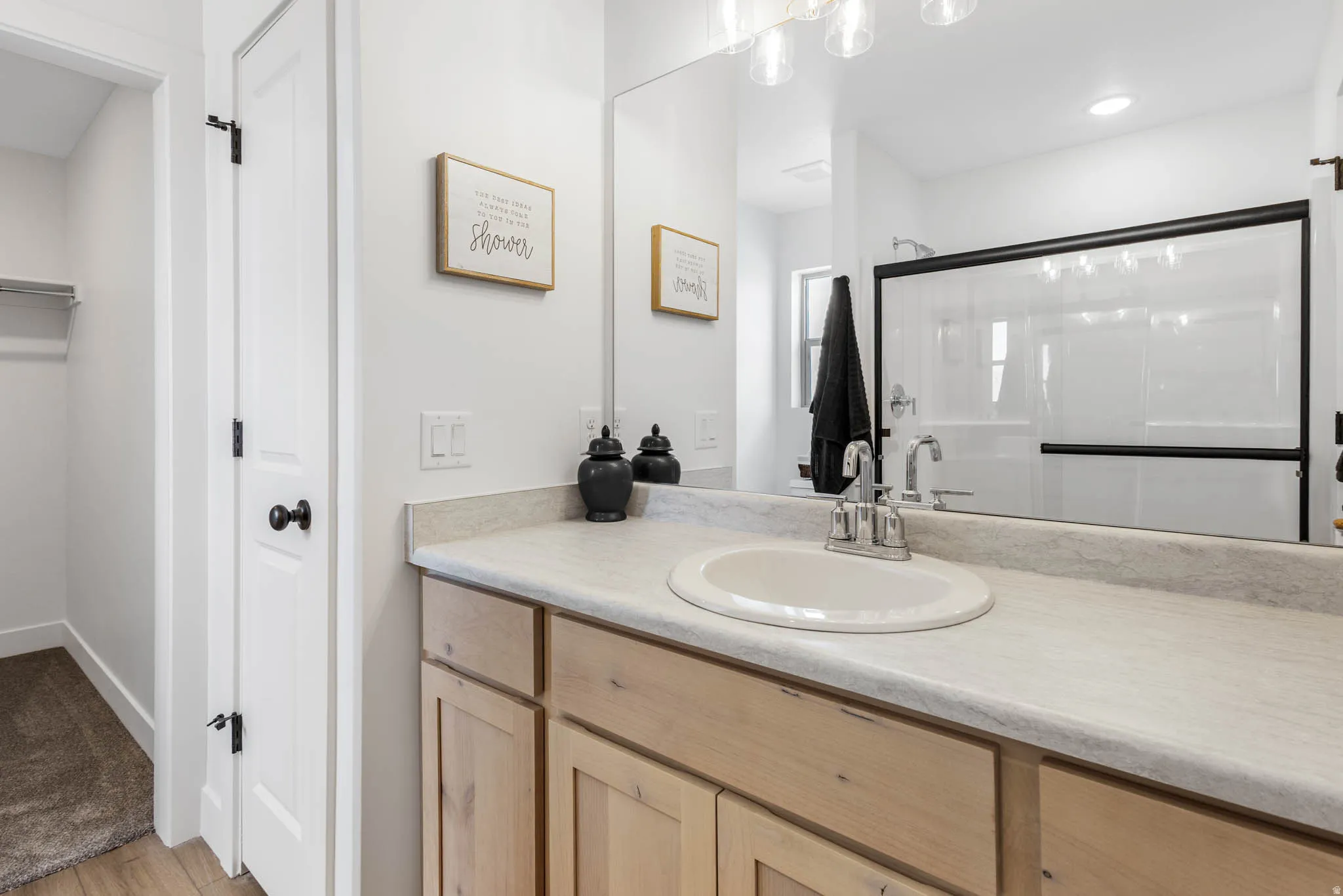 Bathroom vanity featuring a light-toned countertop, an undermount sink with a chrome faucet, and wood-finish cabinetry