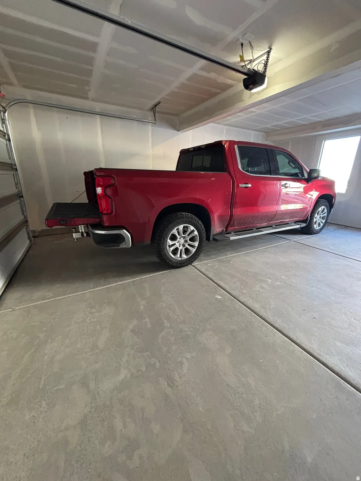 Spacious garage featuring a concrete floor, high ceilings, and a window for natural light