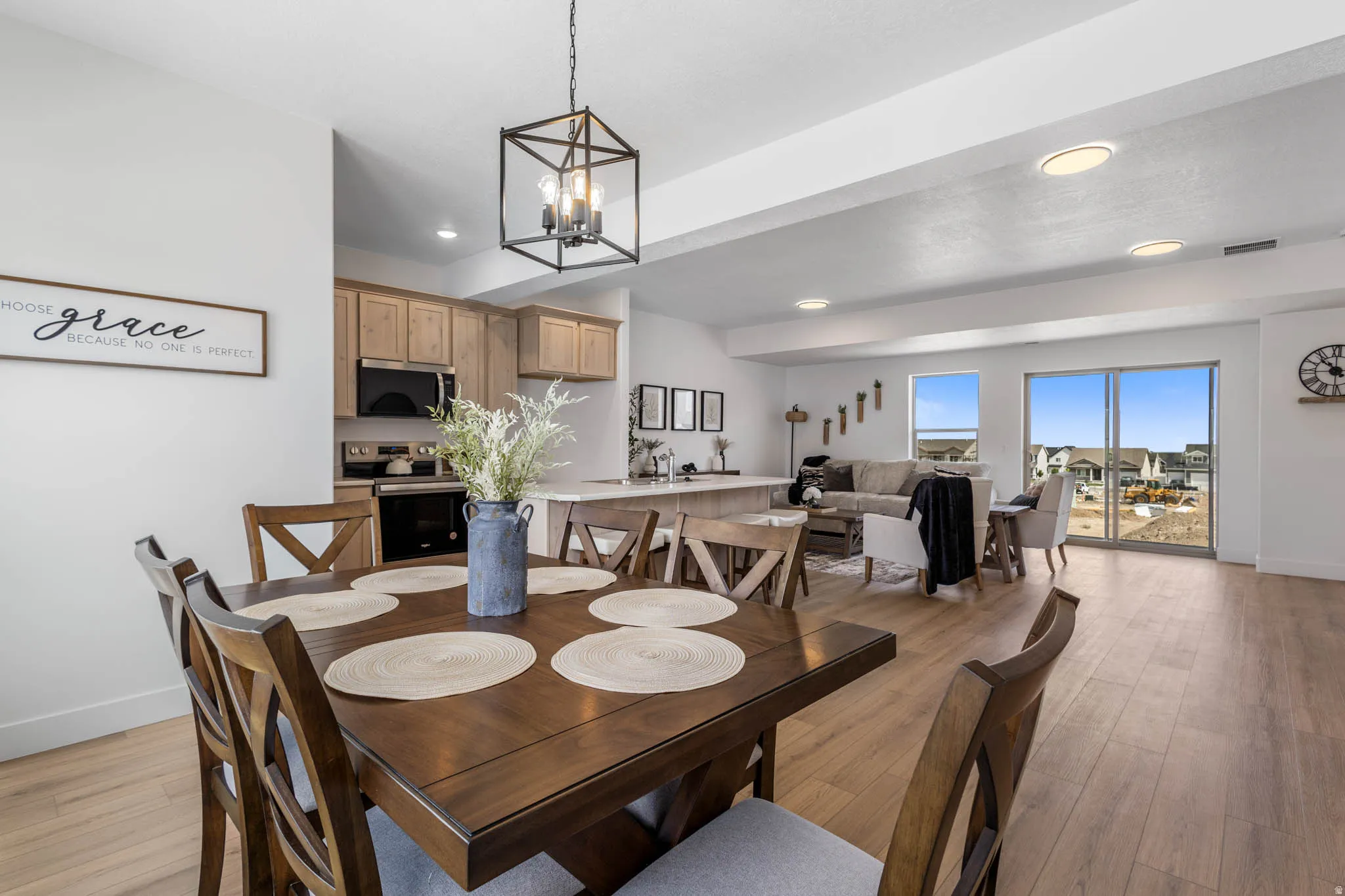 Open-concept living space featuring wood-finish flooring, recessed lighting, and a contemporary pendant light fixture