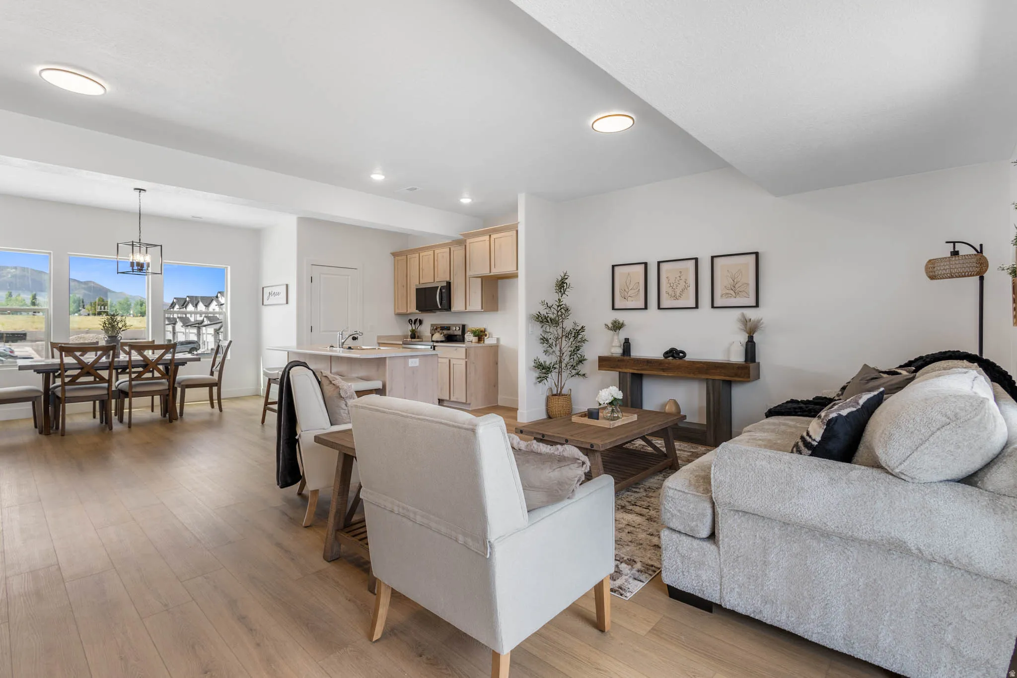 Open-concept living space featuring wood-finish flooring, recessed lighting, and a dining area with multiple windows