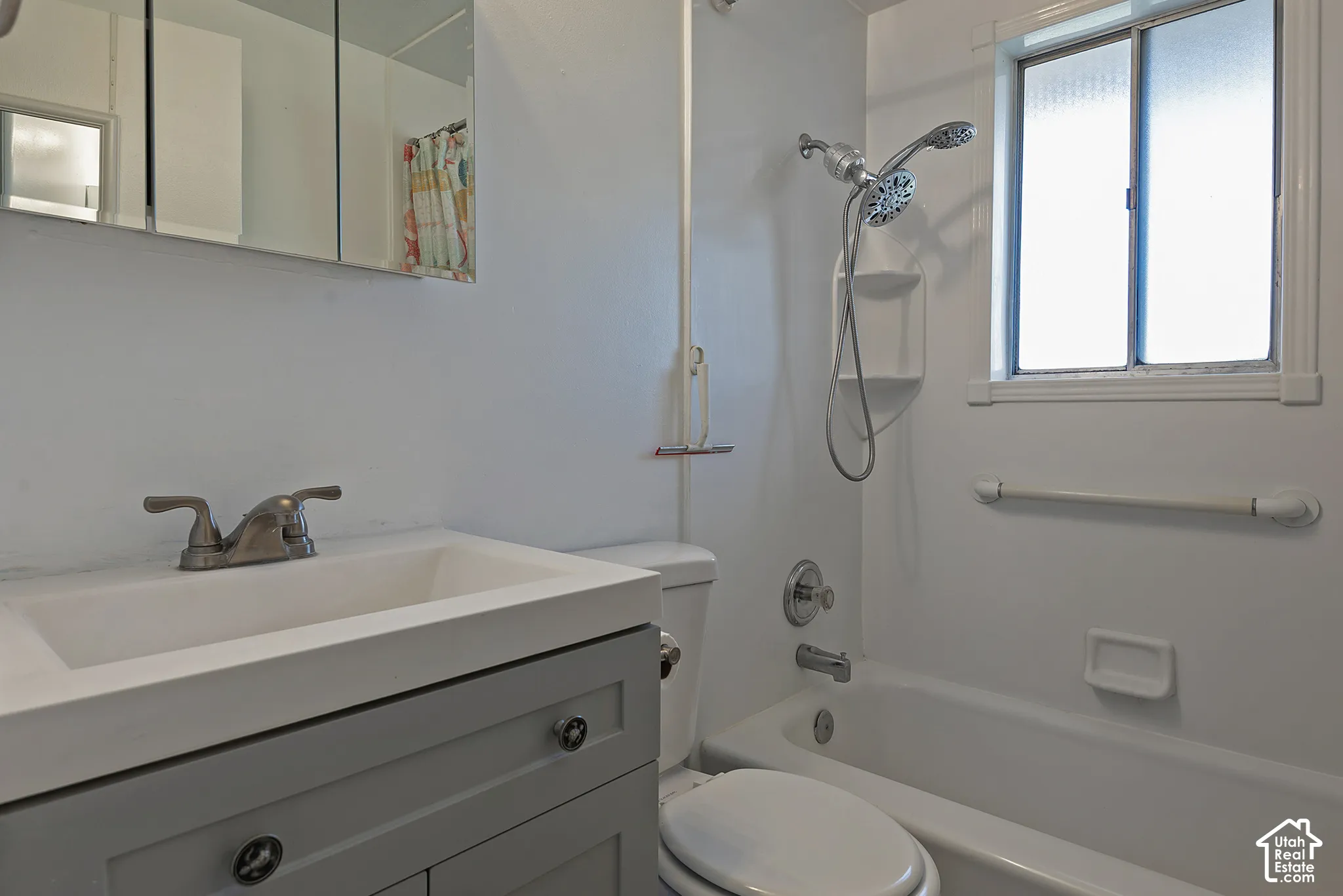 Bathroom featuring a vanity with integrated sink, brushed nickel faucet, and a medicine cabinet with mirrored doors