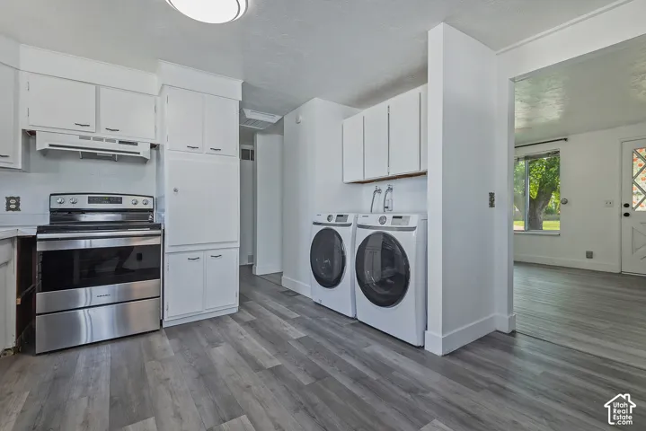 Kitchen area featuring white cabinetry, stainless steel range, and wood-finish flooring