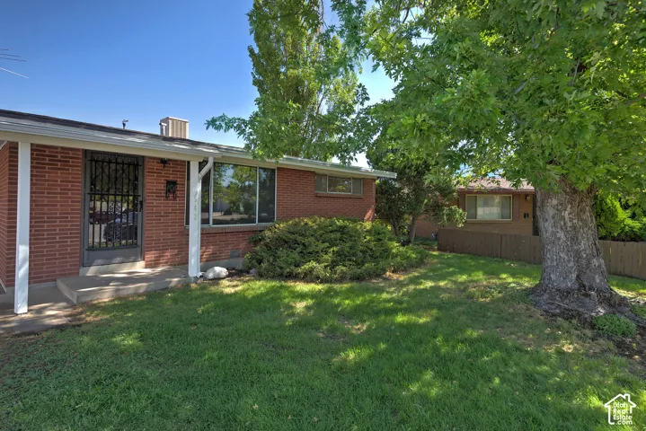 Front exterior featuring red brick siding, a covered porch entry, and large windows