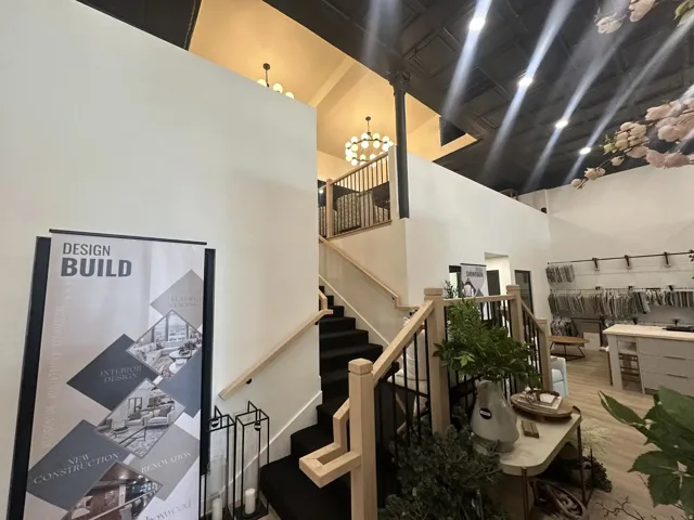 Two-story entry with a black carpeted staircase, light wood handrails, and black metal balusters