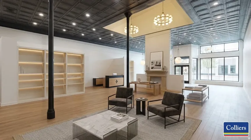 Open-concept interior featuring wood-finish flooring, high ceilings with recessed lighting, and large storefront windows