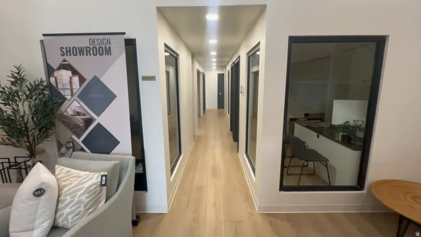 Hallway with light wood-finish flooring, recessed lighting, and white walls