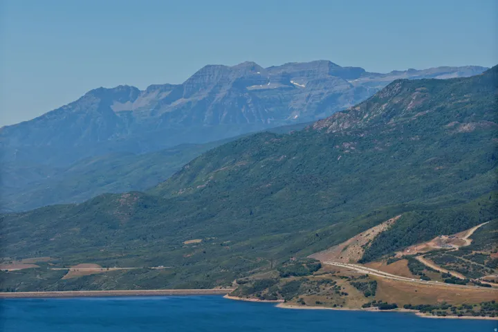 Expansive mountain landscape with a large body of water, and distant peaks