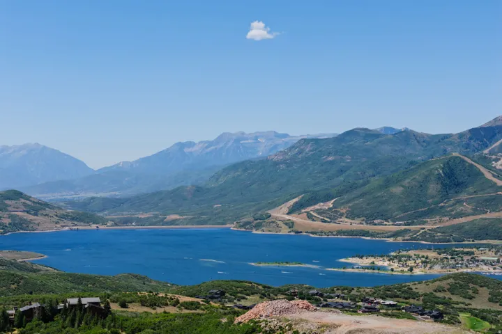 Expansive lake with surrounding mountainous terrain and scattered residential structures
