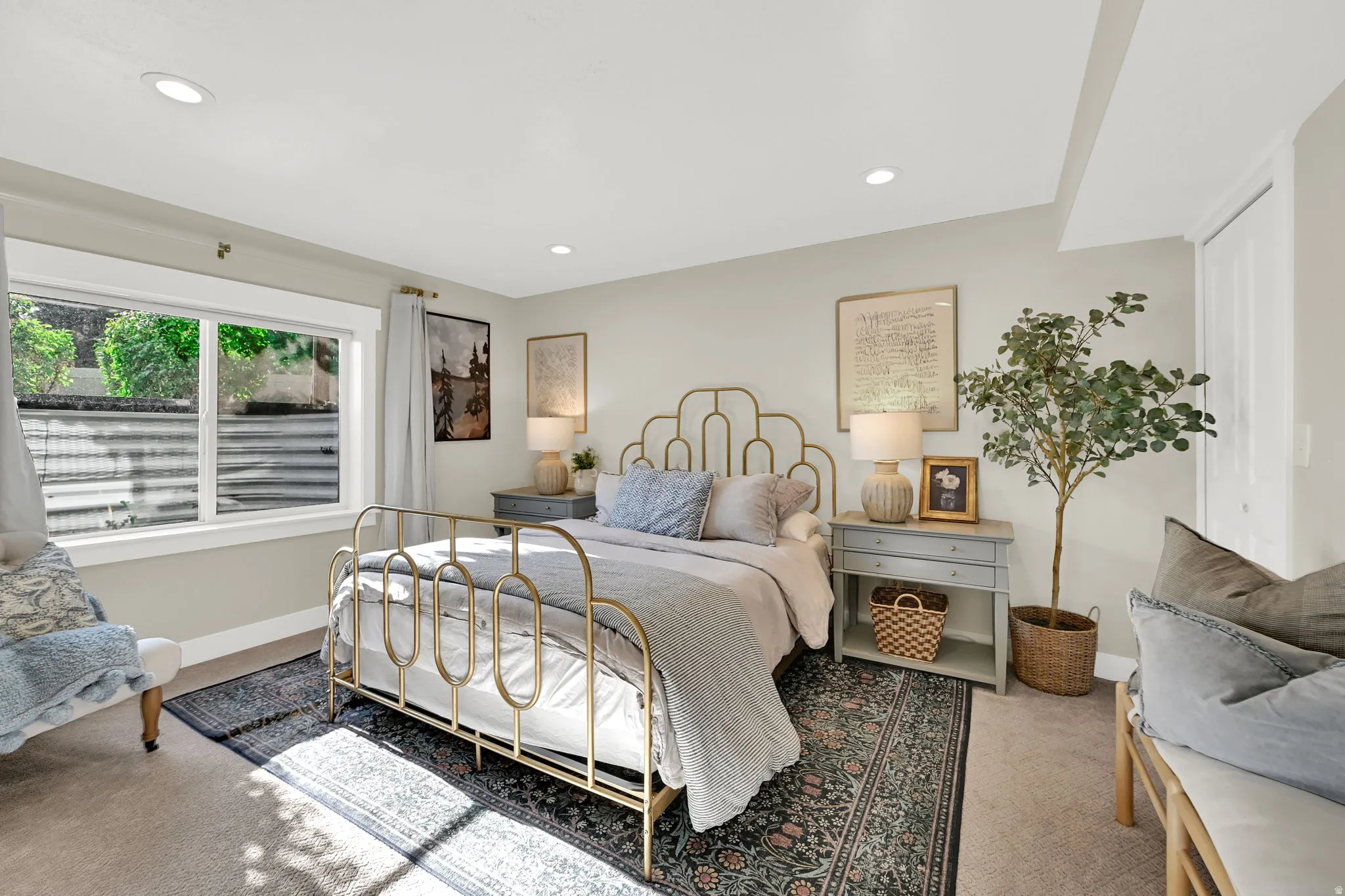 Carpeted bedroom featuring a large window with white trim, recessed lighting, and a white paneled door