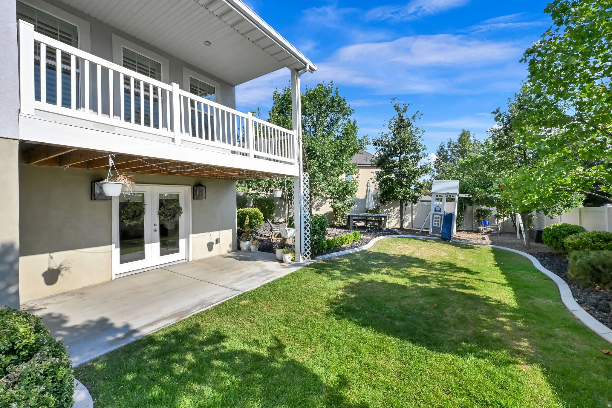Expansive backyard featuring a manicured lawn, established trees, and defined landscaping borders