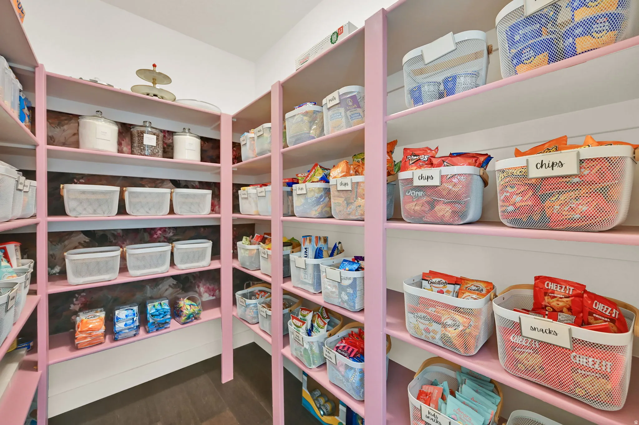 Custom pantry featuring extensive shelving, a corner configuration, and dark wood-finish flooring
