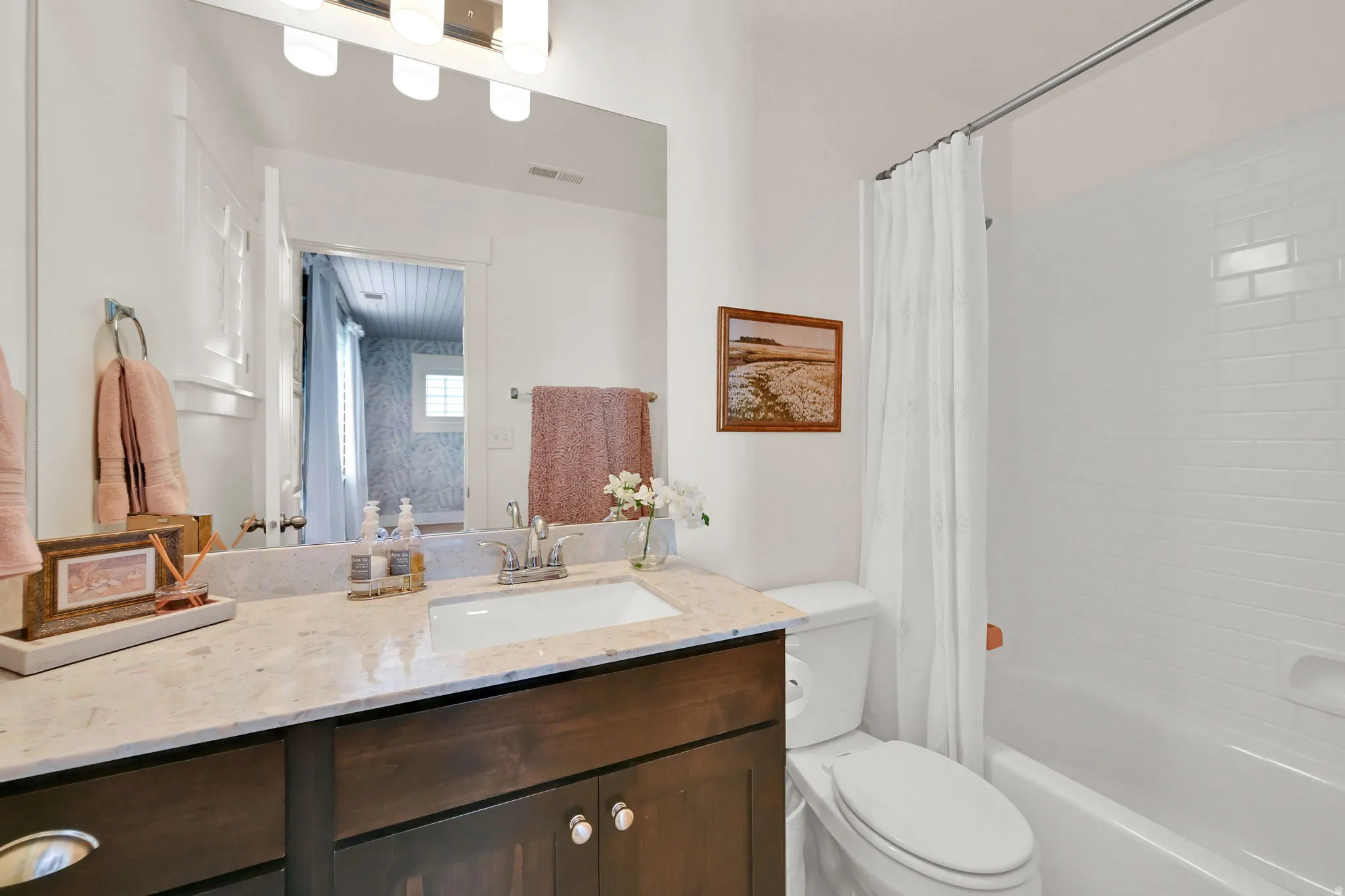 Bathroom with a dark wood-finish vanity, light-toned countertop, and undermount sink