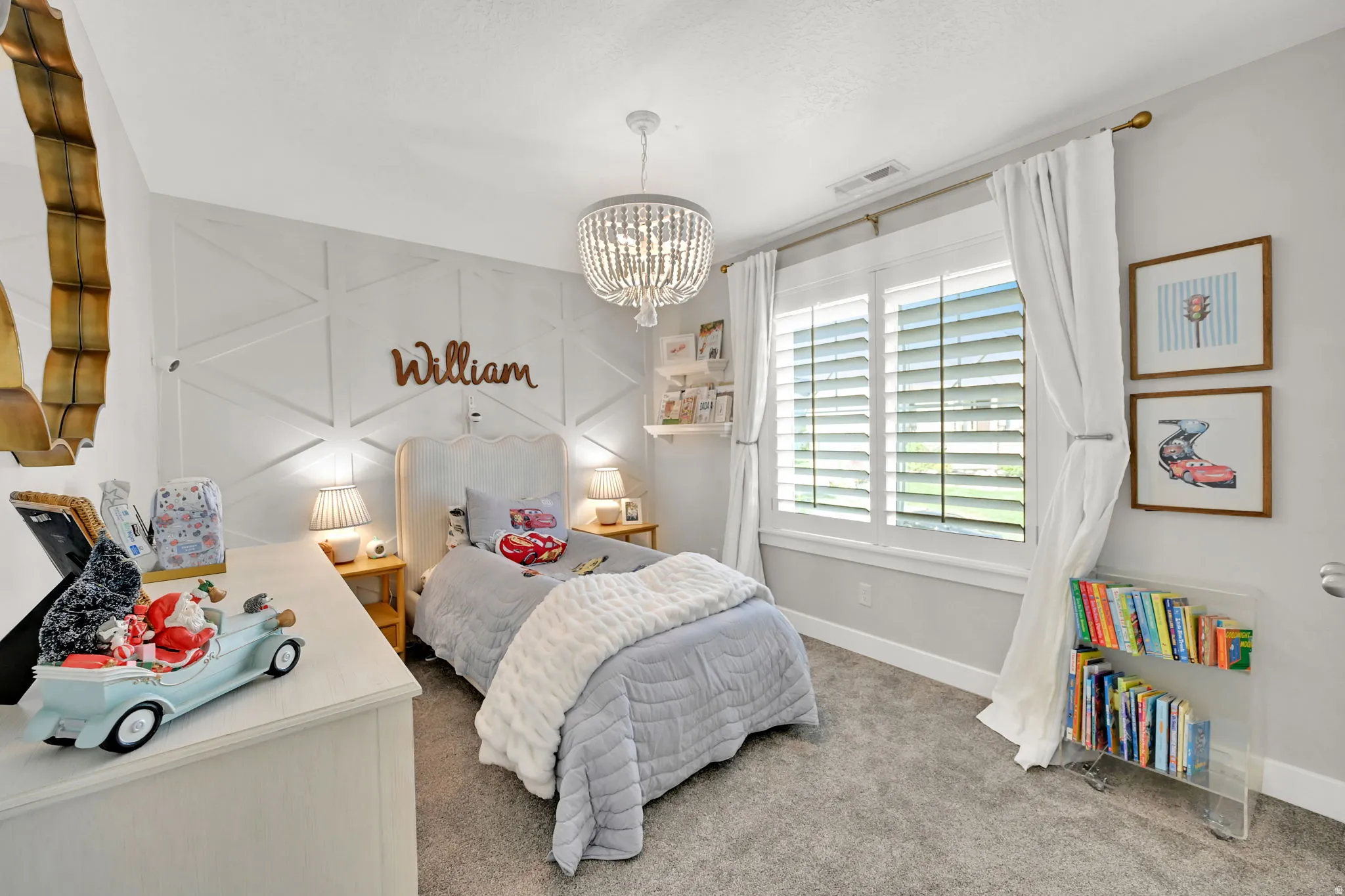 Spacious room featuring a decorative accent wall, white plantation shutters, and a crystal chandelier