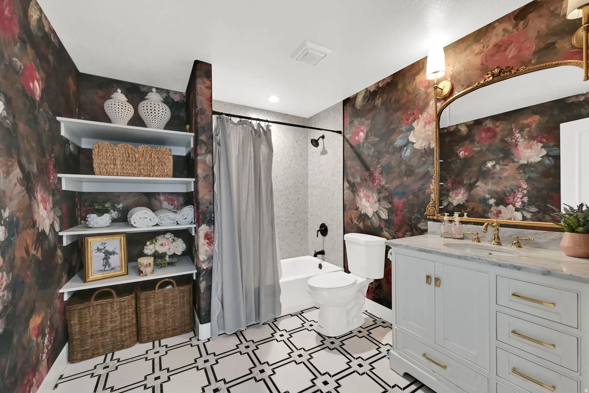 Bathroom featuring a single-sink vanity with a light-colored countertop and brass-finish faucet, a toilet, and a shower-tub combination