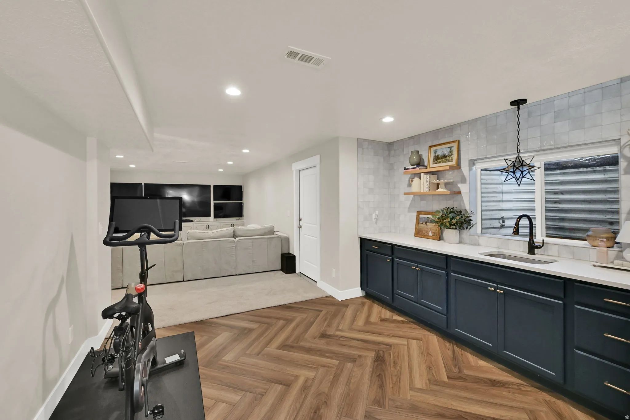 Lower-level space featuring wood-finish flooring in a herringbone pattern