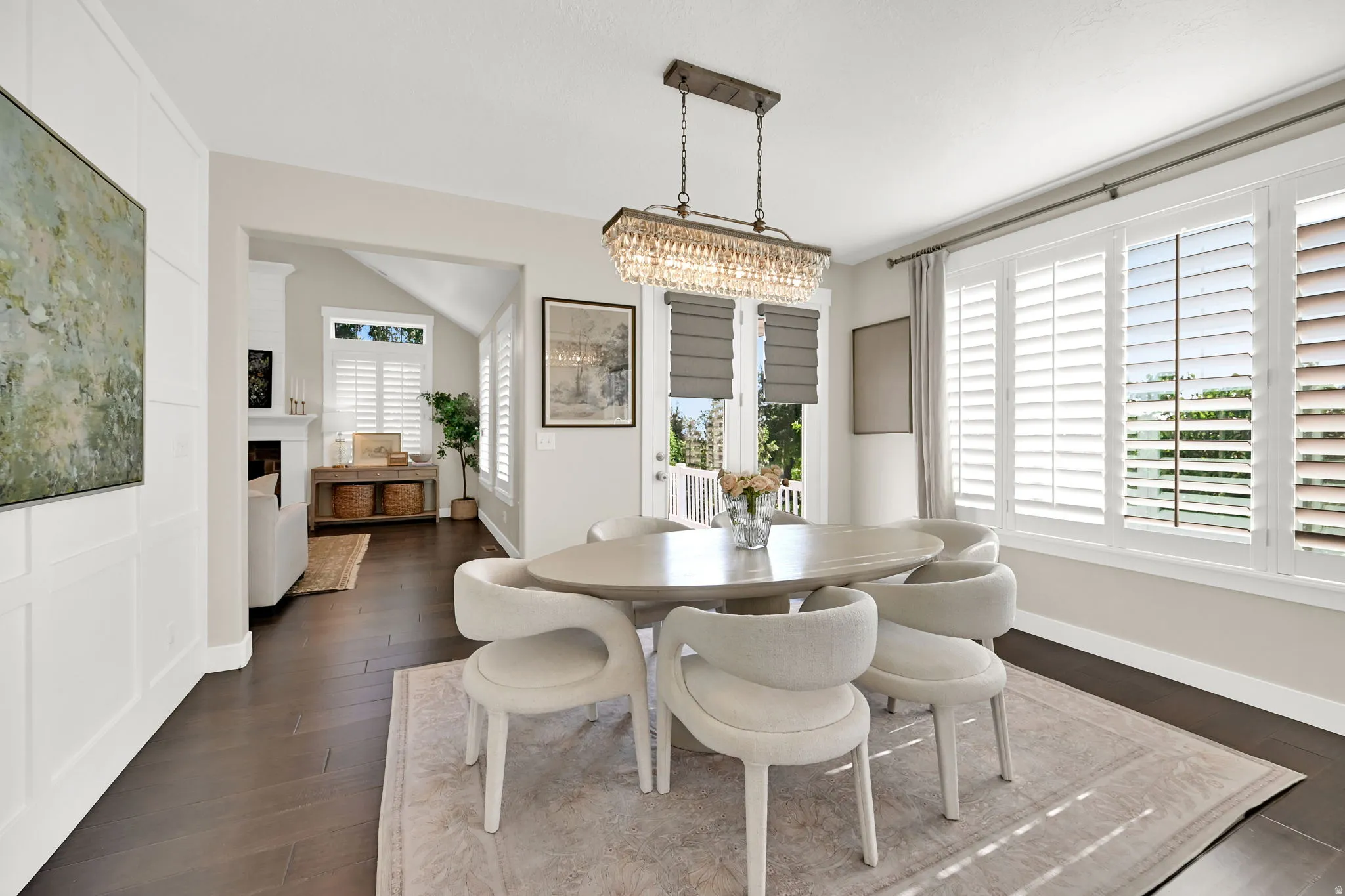 Dining area featuring wood-finish flooring, white paneling, and an ornate chandelier