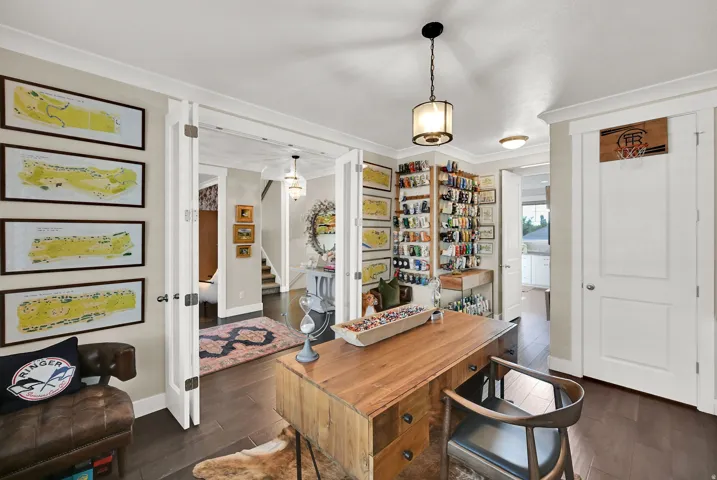 Office space featuring dark wood-finish flooring, light neutral wall tones, and white trim