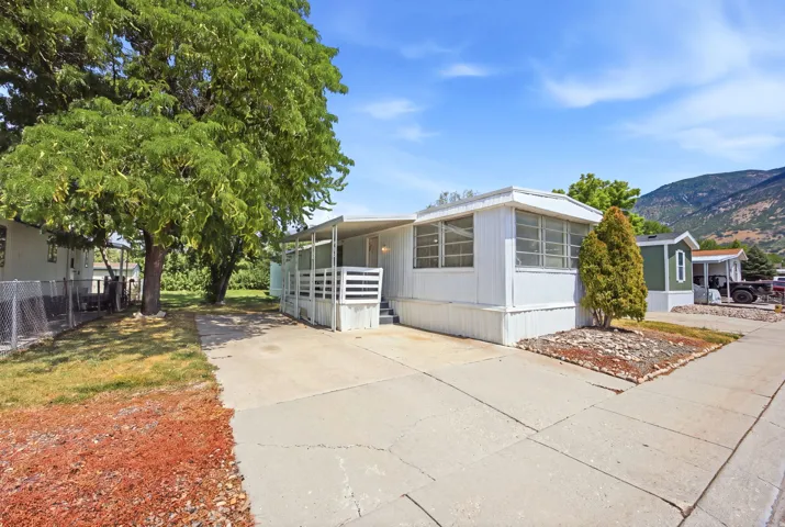 White-sided single-story residence featuring a covered porch, an attached screened-in sunroom, and an extended driveway