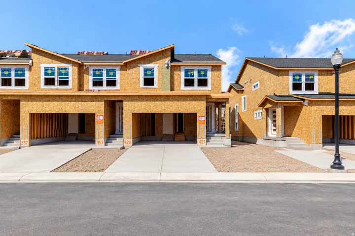 New construction townhomes featuring attached garages, individual entryways, and contemporary window placement