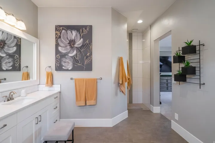Bathroom featuring a white vanity with a single sink, chrome faucet, and white subway tile backsplash