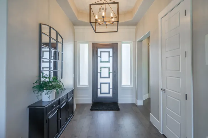 Entryway featuring a dark wood-finish door with decorative glass, two sidelight windows, and dark wood-finish flooring