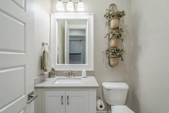 Vanity with a rectangular undermount sink, light-colored countertop, white shaker-style cabinetry, and brushed nickel fixtures