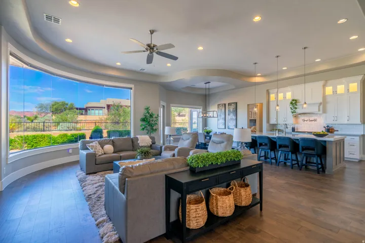 Expansive open-concept living space featuring wood-finish flooring, recessed lighting, and a tray ceiling