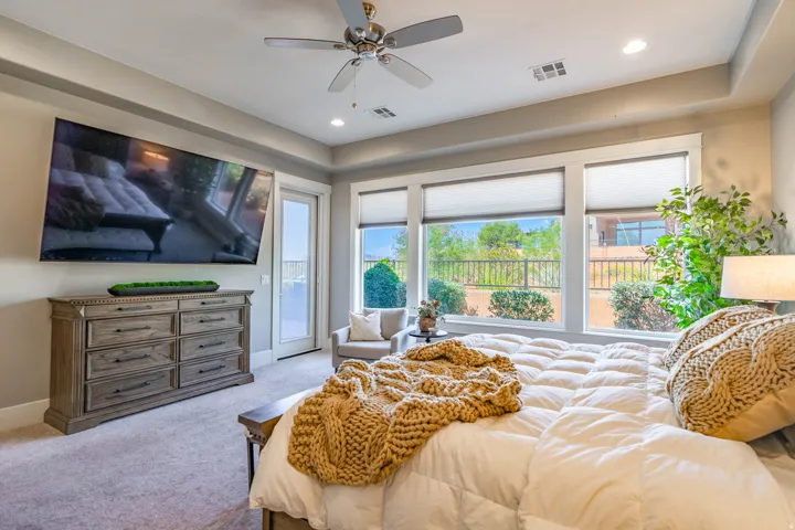 Spacious room featuring multiple large windows, a ceiling fan, recessed lighting, and a tray ceiling