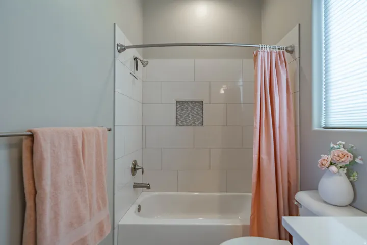 Bathtub with subway tile surround and mosaic niche