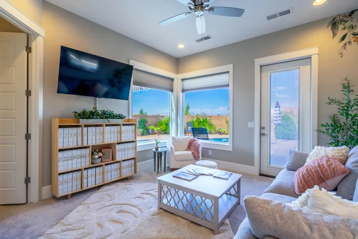 Living area featuring recessed lighting, a ceiling fan, and large windows with roller shades