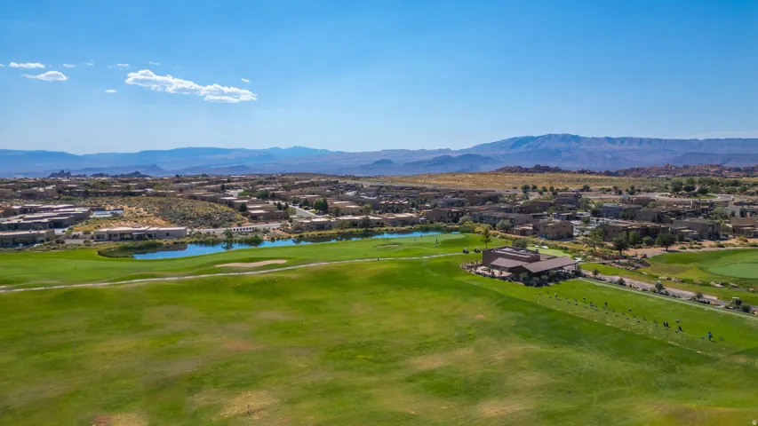 Expansive green golf course with a central water feature, surrounded by residential properties