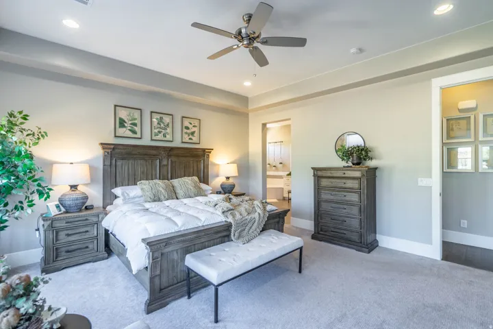 Carpeted bedroom with a ceiling fan, recessed lighting, and tray ceiling detail
