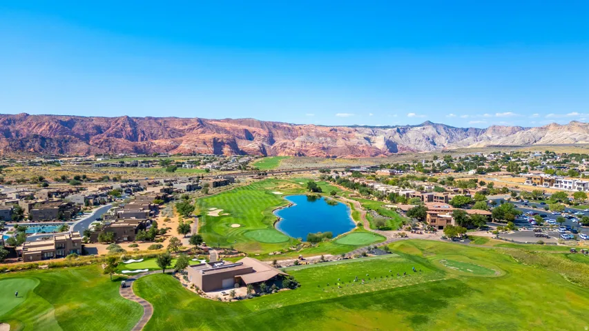 Expansive golf course setting featuring manicured greens and a central water feature