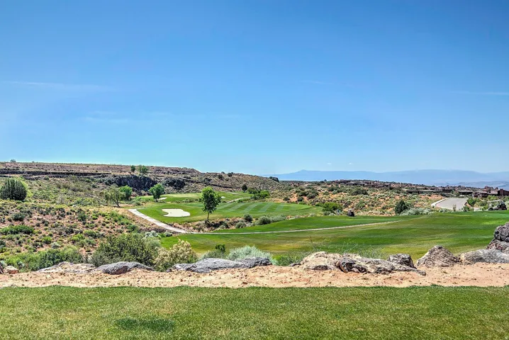 Expansive golf course frontage with a manicured green and sand traps