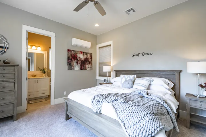 Spacious bedroom featuring light-toned carpeting and neutral wall tones