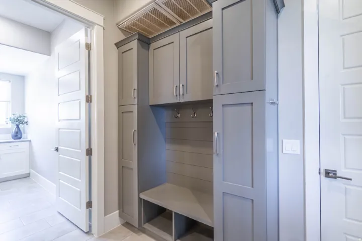 Built-in mudroom cabinetry featuring a bench with integrated storage, shaker-style doors, and metal hardware