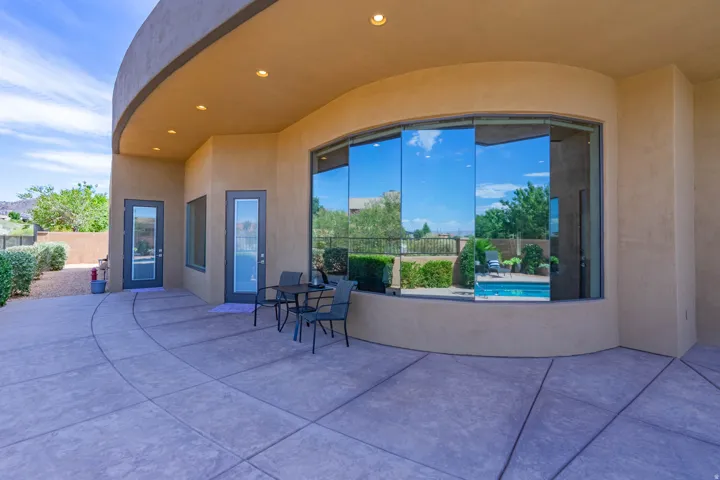 Curved patio with stamped concrete flooring, featuring an exterior with stucco finish