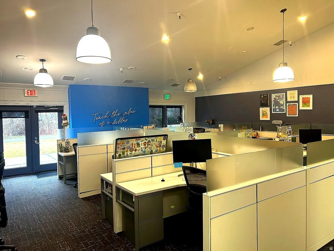 Open-plan office area featuring multiple workstations and pendant lighting