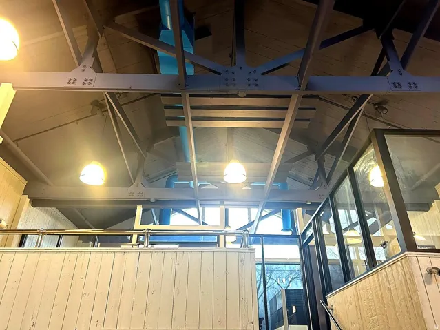 Exposed ceiling trusses featuring metal beams and riveted connections