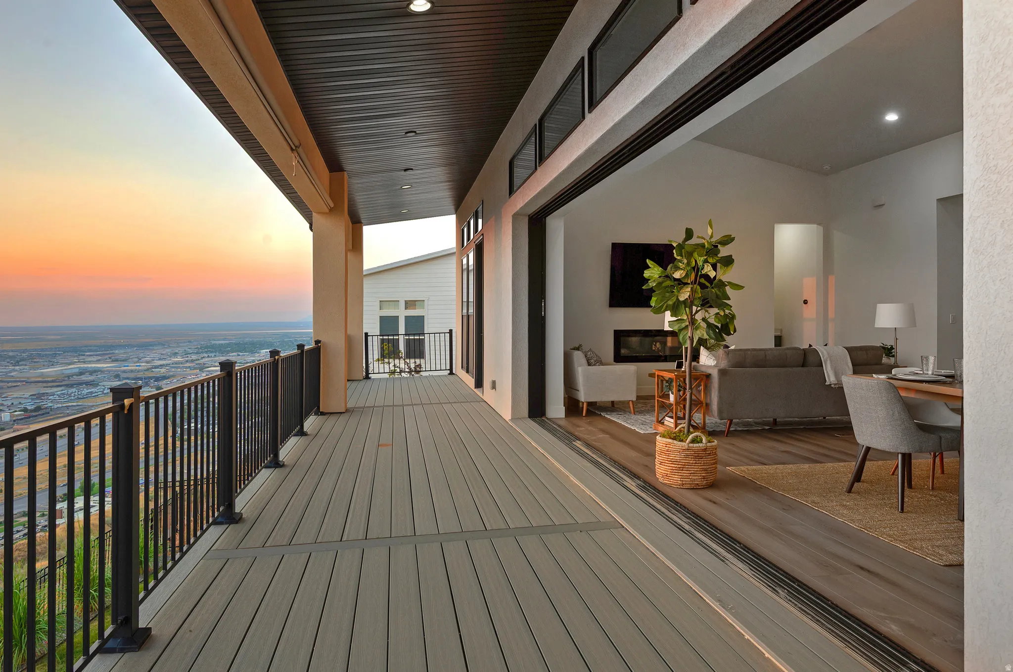Expansive outdoor deck featuring wood-finish flooring and black metal railings